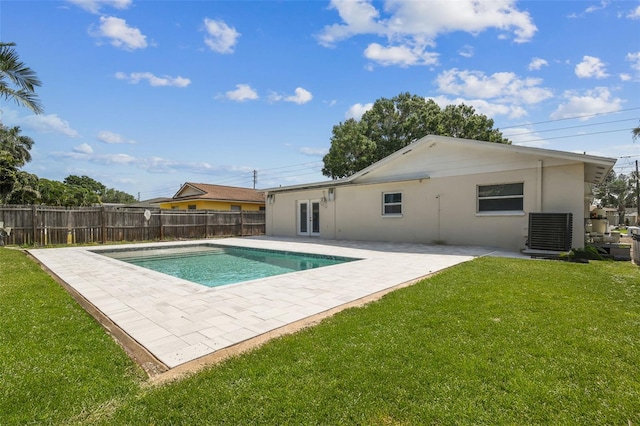 view of swimming pool with central air condition unit, a patio area, french doors, and a lawn