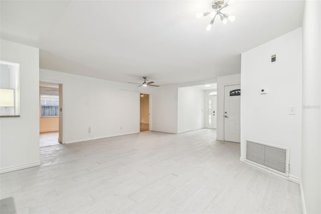 unfurnished room with a notable chandelier and light wood-type flooring