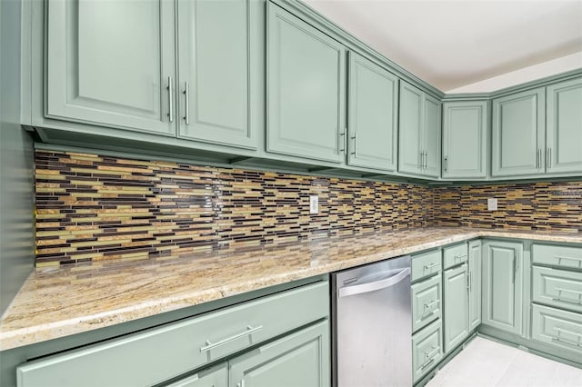 kitchen featuring backsplash, green cabinets, and light stone counters