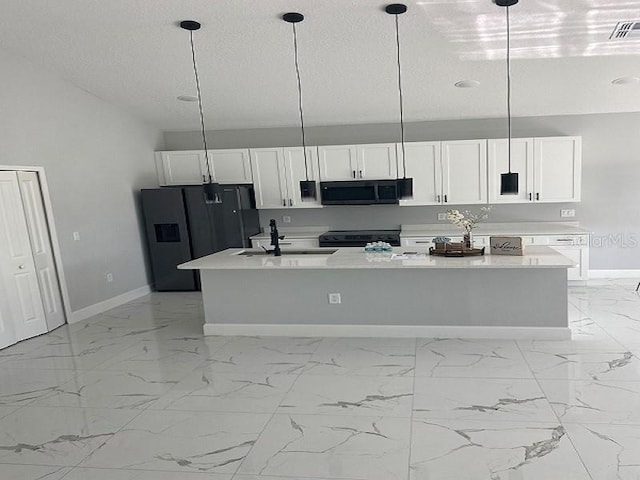 kitchen with hanging light fixtures, black appliances, an island with sink, and light tile flooring