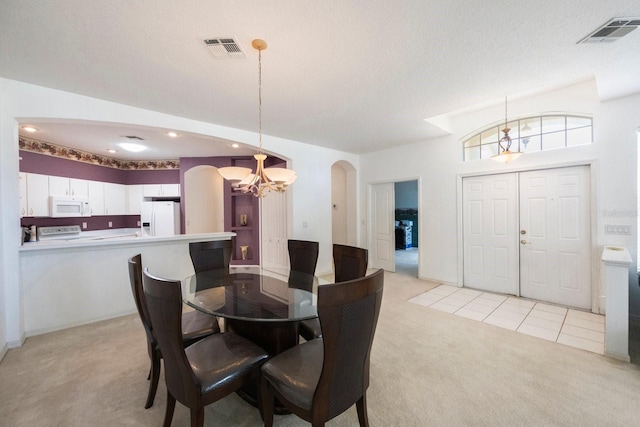 dining space featuring vaulted ceiling, a textured ceiling, light carpet, and a chandelier