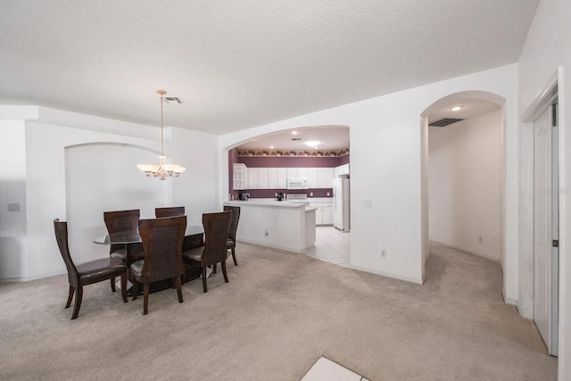 dining space with an inviting chandelier and light colored carpet