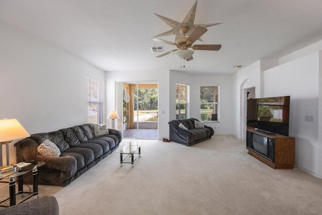 carpeted living room with ceiling fan