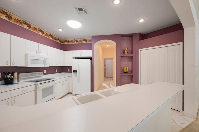 kitchen featuring white cabinets, sink, white appliances, and light tile floors