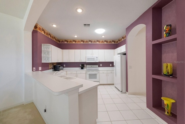 kitchen with white appliances, white cabinets, kitchen peninsula, sink, and light tile floors