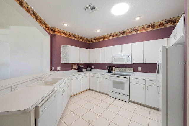 kitchen featuring sink, white cabinetry, white appliances, and light tile flooring