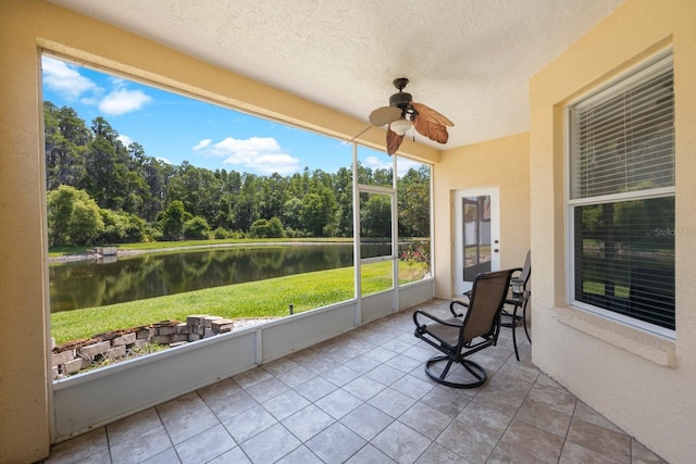 unfurnished sunroom with ceiling fan and a water view