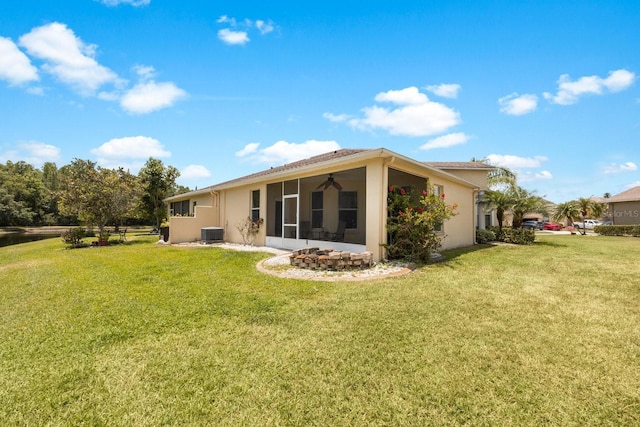 back of house with a lawn, a sunroom, and central AC unit