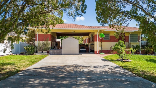 single story home with a front lawn, a storage unit, and a carport