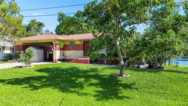 ranch-style home featuring a front lawn and a carport