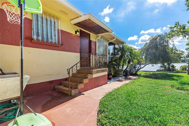 doorway to property featuring a yard