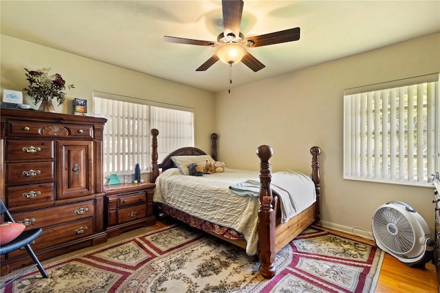 bedroom featuring multiple windows, ceiling fan, and light wood-type flooring