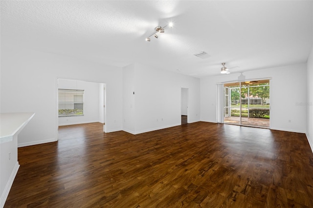 empty room featuring dark wood-type flooring, ceiling fan, and rail lighting