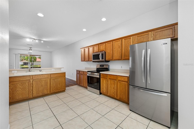 kitchen with appliances with stainless steel finishes, ceiling fan, and light tile floors