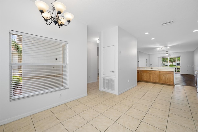 interior space with sink, light tile flooring, and ceiling fan with notable chandelier