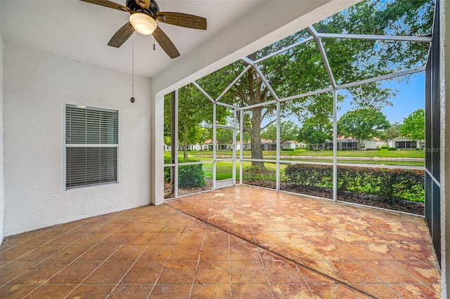 unfurnished sunroom with ceiling fan