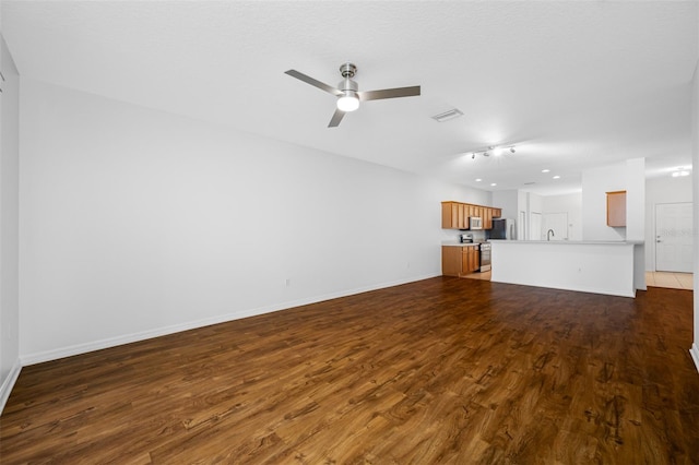 unfurnished living room with dark hardwood / wood-style floors and ceiling fan