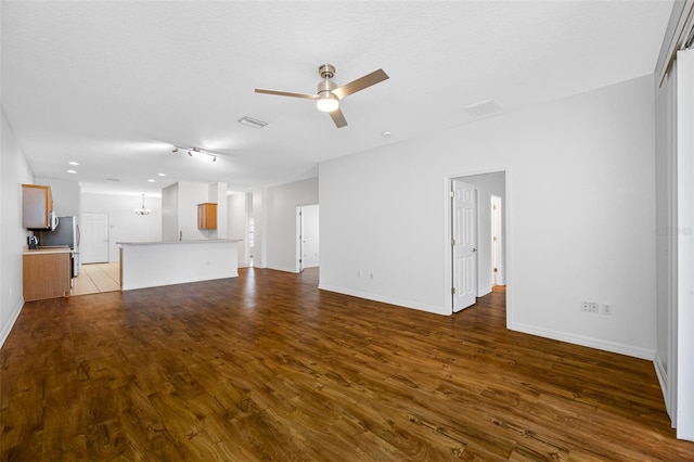 unfurnished living room with ceiling fan, dark hardwood / wood-style flooring, and a textured ceiling