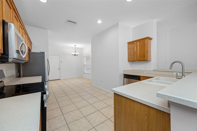 kitchen with appliances with stainless steel finishes, sink, a chandelier, and light tile flooring