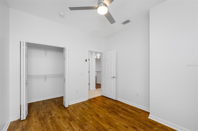 unfurnished bedroom with dark hardwood / wood-style floors, a closet, and ceiling fan