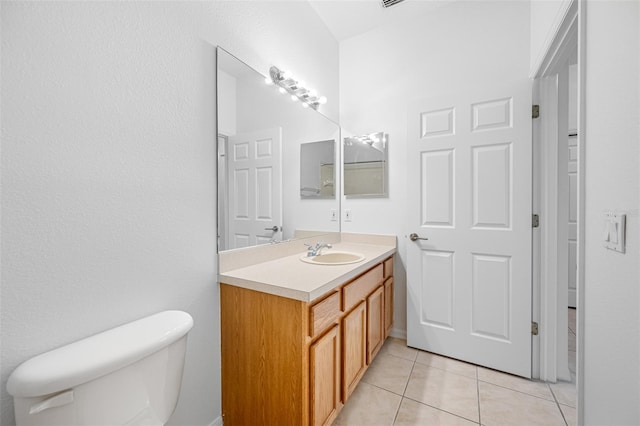 bathroom with tile floors, toilet, and large vanity