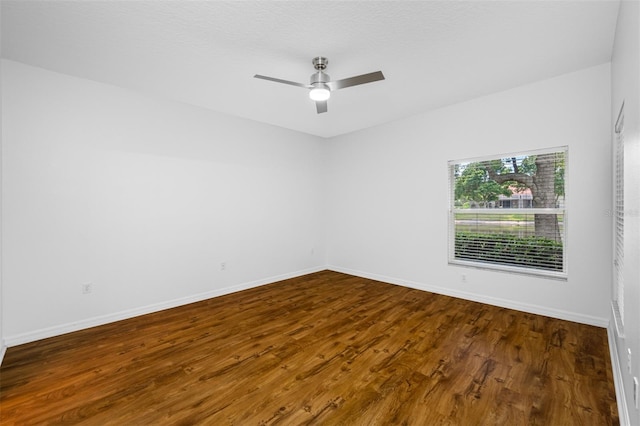 empty room with ceiling fan and dark hardwood / wood-style floors