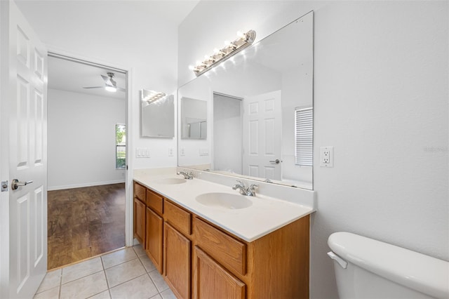 bathroom featuring oversized vanity, ceiling fan, toilet, tile floors, and double sink