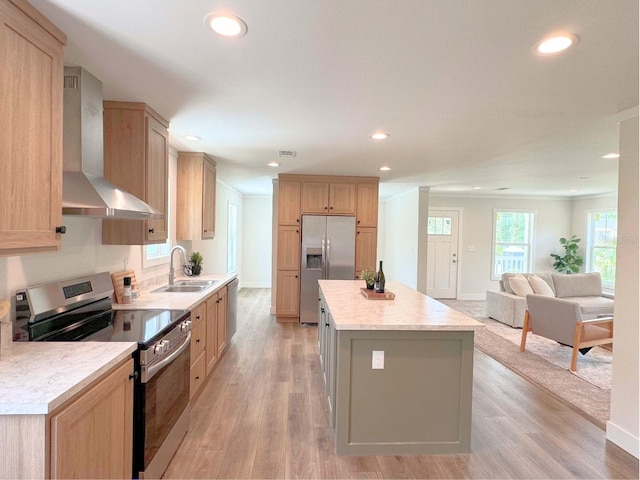 kitchen with light hardwood / wood-style floors, stainless steel appliances, a center island, wall chimney exhaust hood, and sink