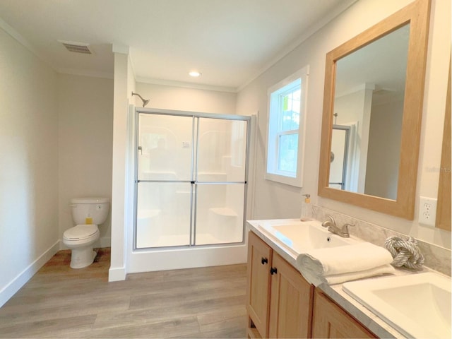 bathroom featuring a shower with shower door, hardwood / wood-style flooring, toilet, and large vanity