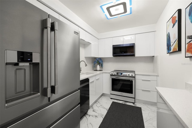 kitchen with sink, light tile floors, white cabinetry, and appliances with stainless steel finishes