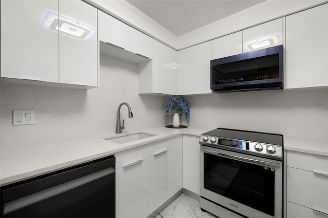 kitchen featuring sink, white cabinets, light tile floors, and stainless steel appliances