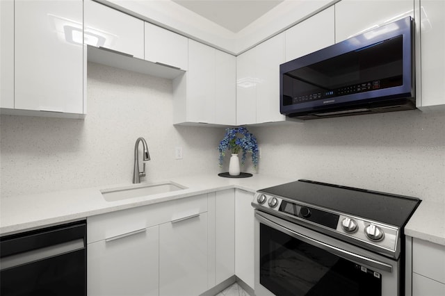 kitchen with sink, stainless steel appliances, tasteful backsplash, and white cabinetry