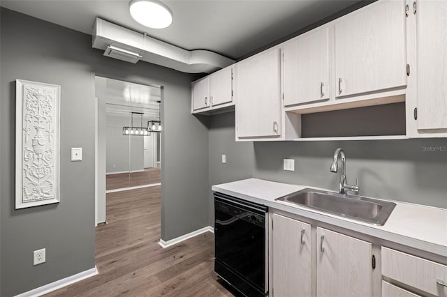 kitchen with sink, dishwasher, pendant lighting, and dark wood-type flooring