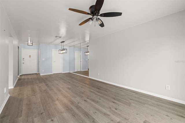 unfurnished living room featuring ceiling fan and hardwood / wood-style floors