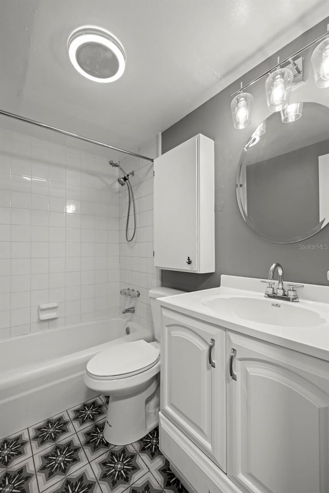 full bathroom with tile floors, vanity, toilet, and tiled shower / bath combo