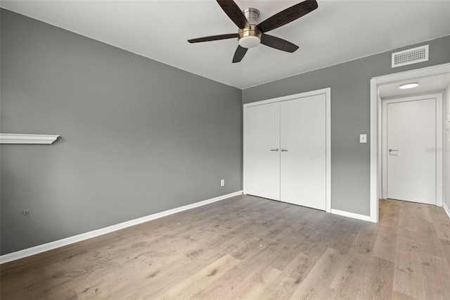 unfurnished bedroom featuring ceiling fan, a closet, and hardwood / wood-style floors