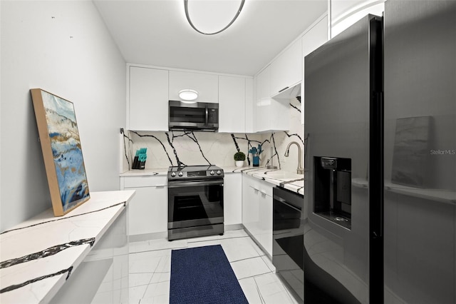 kitchen with white cabinetry, stainless steel appliances, backsplash, sink, and light tile floors