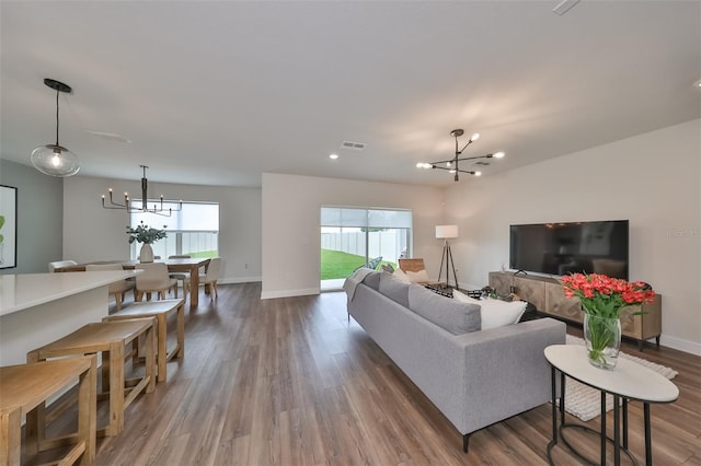 living room with a notable chandelier and dark hardwood / wood-style flooring