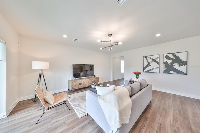 living room featuring light hardwood / wood-style floors and an inviting chandelier