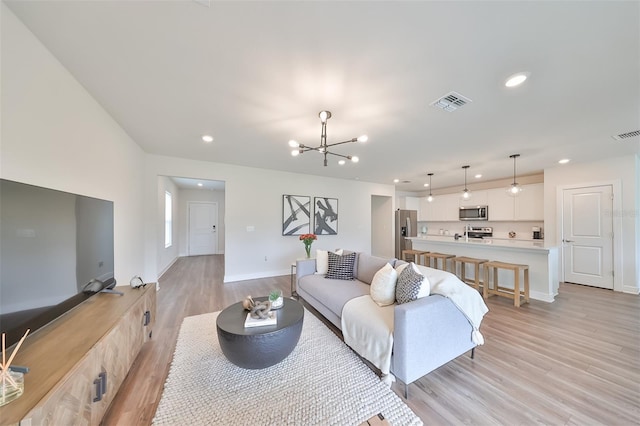 living room featuring a chandelier and light hardwood / wood-style flooring