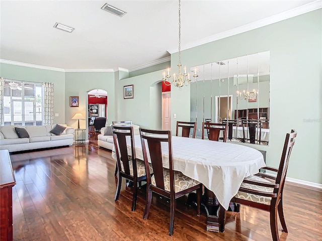 dining room featuring dark hardwood / wood-style floors, ornamental molding, and a chandelier