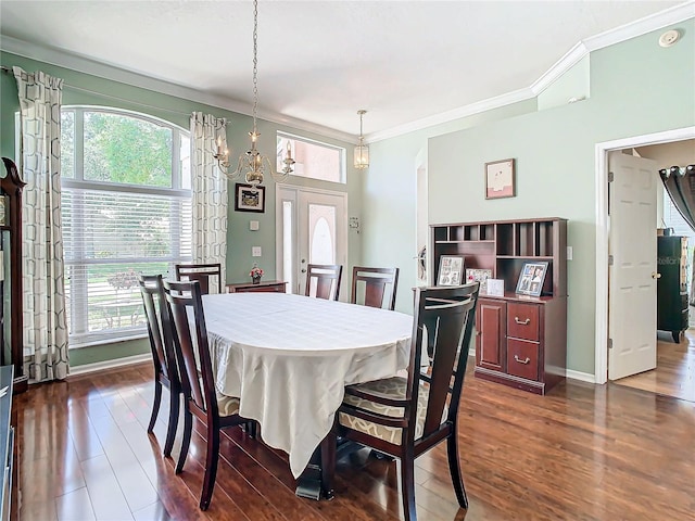 dining area featuring ornamental molding, a wealth of natural light, dark wood-type flooring, and a notable chandelier