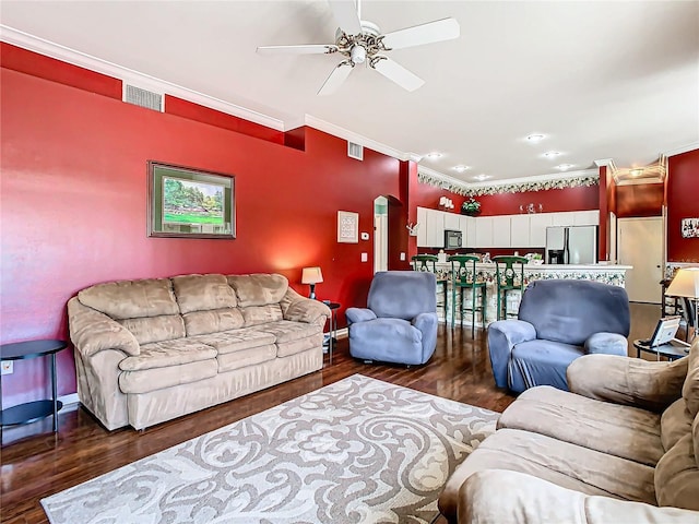 living room featuring dark hardwood / wood-style flooring, ceiling fan, and ornamental molding