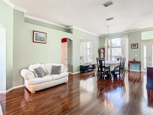 dining room with crown molding, dark hardwood / wood-style flooring, a textured ceiling, and an inviting chandelier