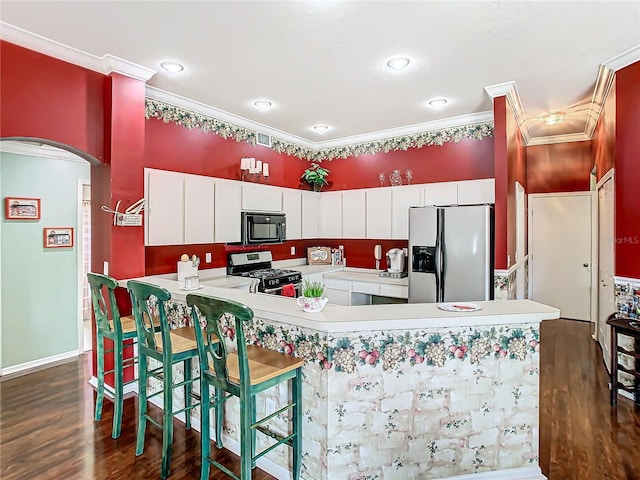 kitchen with gas range oven, stainless steel fridge, dark hardwood / wood-style flooring, and white cabinets