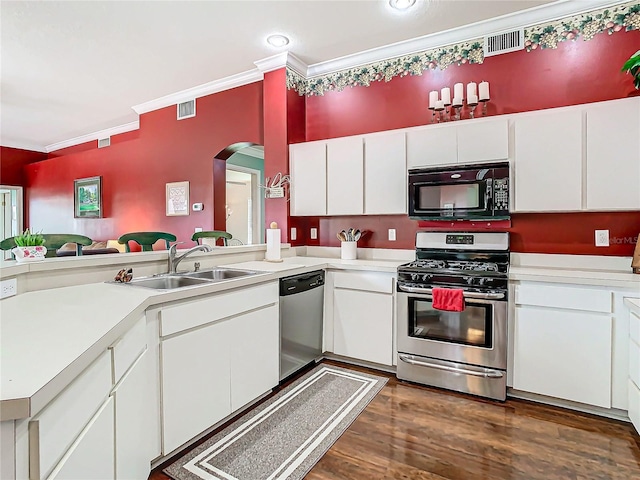 kitchen featuring stainless steel appliances, dark wood-type flooring, crown molding, sink, and white cabinetry