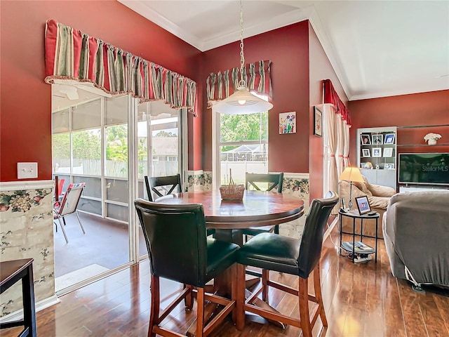 dining area with hardwood / wood-style floors and crown molding