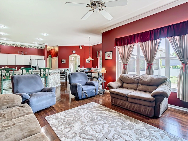 living room with dark hardwood / wood-style flooring, ceiling fan, and crown molding