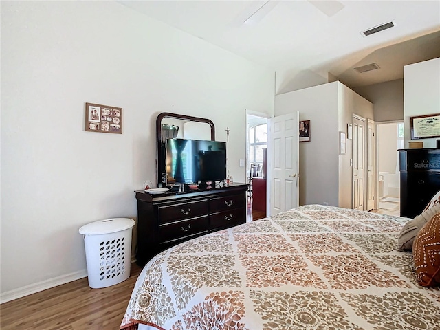 bedroom featuring wood-type flooring, ensuite bathroom, vaulted ceiling, and ceiling fan