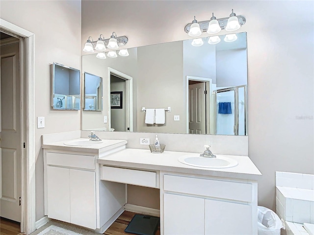 bathroom with hardwood / wood-style flooring, vanity, and shower with separate bathtub